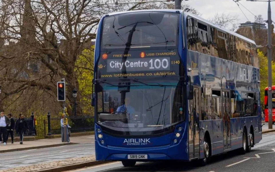 Front of a blue Airlink 100 airport bus
