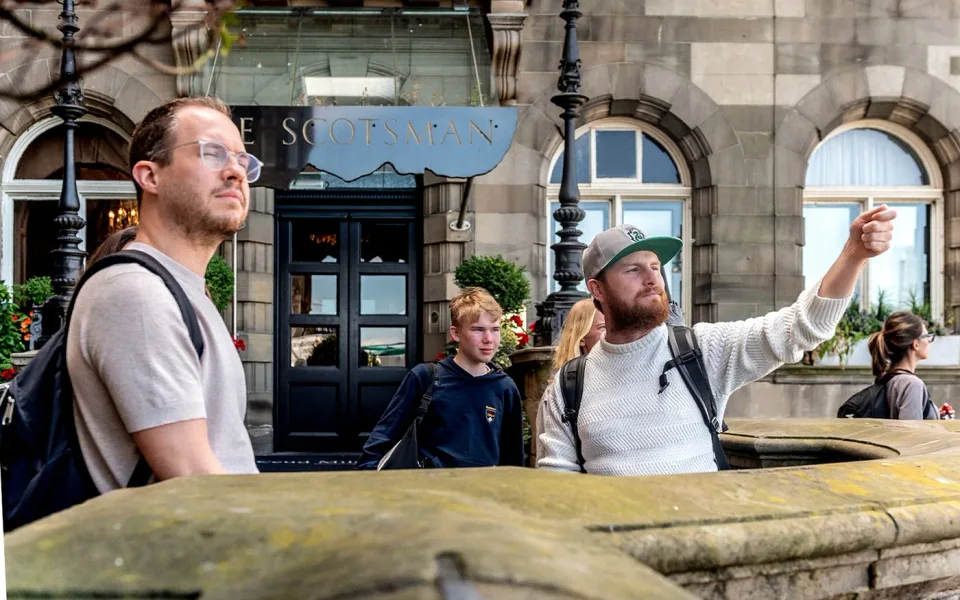 Guide weist während einer Themen‑Stadtrundfahrt auf Sehenswürdigkeiten der Altstadt hin