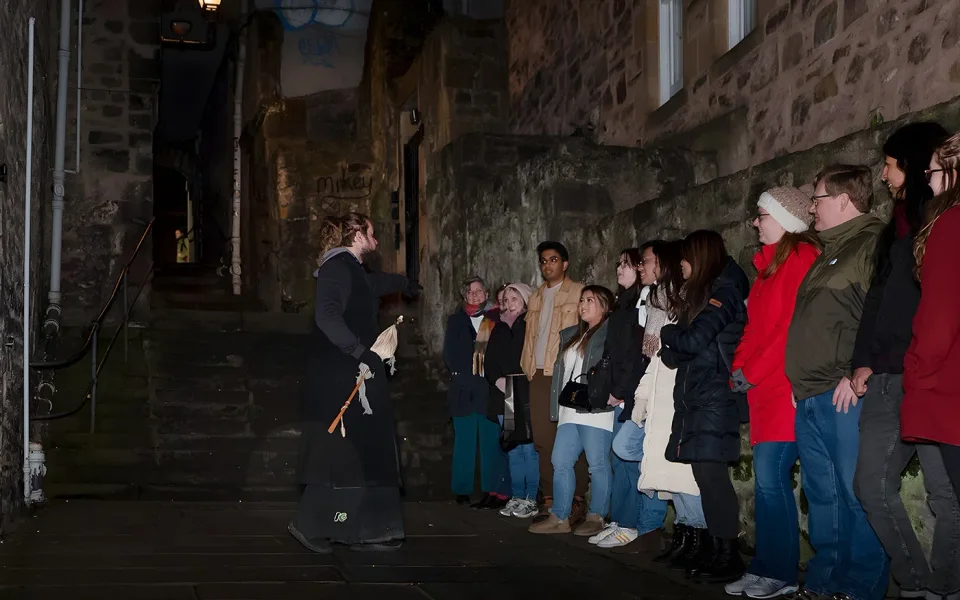 Guided group exploring an Old Town close after dark