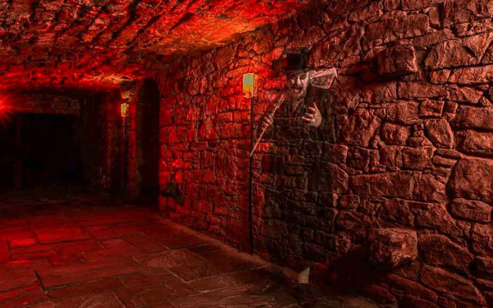 Red-lit stone chamber on an Edinburgh underground tour