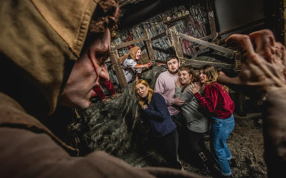 Performer speaking to visitors inside the Edinburgh Dungeon