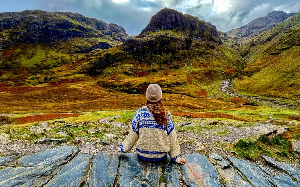 Visitor looking across a rocky Highland landscape