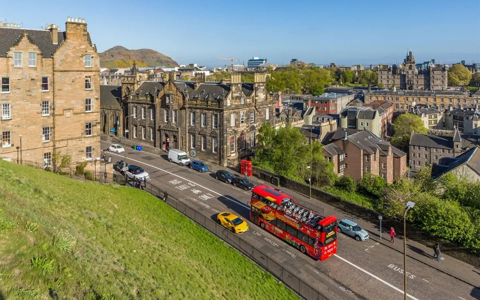 Sightseeing buses travelling below Edinburgh Castle